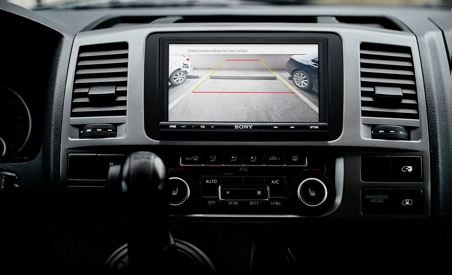 Vista frontal del receptor multimedia digital XAV-1600 con la imagen de la cámara de vista posterior en la pantalla.